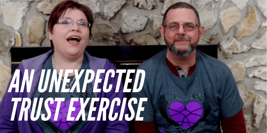 Image of Kayla Lords and John Brownstone smiling at camera with words "An unexpected trust exercise" for the post Video: The First Time We Used Our Safeword Together