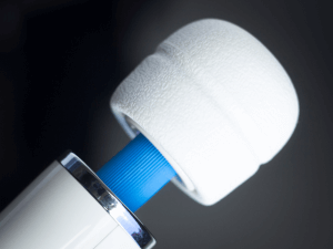 top of wand massager in white with blue neck and top of handle visible over black background